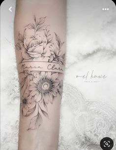 a woman's arm with flowers on it and a ribbon around the wrist that says,