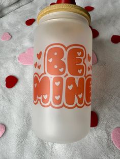 a glass jar sitting on top of a bed covered in pink and red confetti