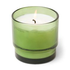 a green glass candle with a single lit candle in it