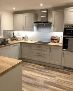 a kitchen with wooden floors and white cabinets