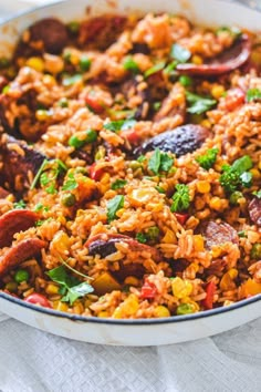 a bowl filled with rice and sausage on top of a table