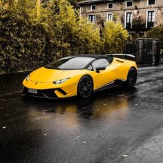 a yellow sports car is parked in the rain