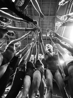 a group of women in bathing suits reaching up to reach for the sky with their hands