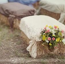 a bunch of hay sitting on top of a field with flowers in front of it