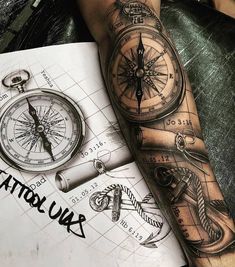 a man with a compass tattoo on his arm next to a piece of paper that says tattoos