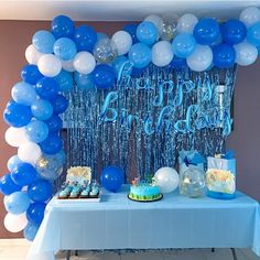 a blue and white birthday party with balloons