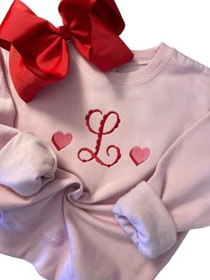 a pink shirt with red hearts and a bow