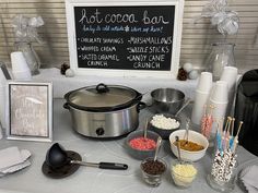 a table topped with lots of food next to a sign that says hot cocoa bar