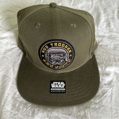 a green hat with a star wars patch on it sitting on a white bed sheet