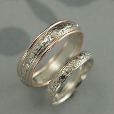 two wedding rings with engraved designs on them