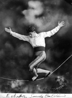 an old black and white photo of a man on a tightrope with his arms outstretched