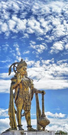 the statue is standing in front of some clouds