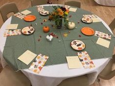 the table is set with plates and place settings for an autumn themed dinner or party