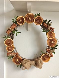 an orange and cinnamon wreath hangs on the wall