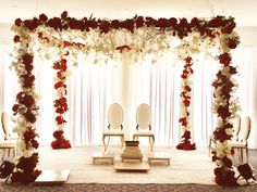 a decorated stage with chairs and flowers on it