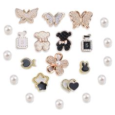 a bunch of different types of brooches and pins on a white background with pearls