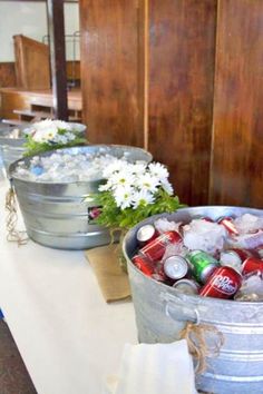 two buckets filled with ice and flowers on a table