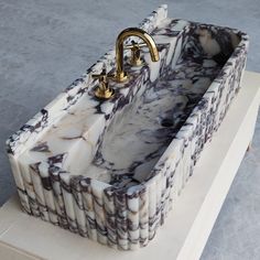 a marble sink sitting on top of a wooden stand