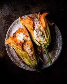 two grilled vegetables on a plate with sour cream and seasoning sprinkles