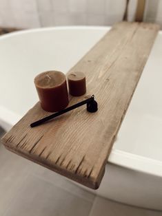 two candles sit on top of a wooden tray