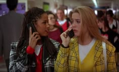 two women talking on cell phones in a crowded room