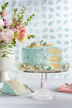 a cake with blue frosting and gold sprinkles on it sitting on a table