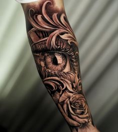 a person with a tattoo on their arm has an eye and roses in the background