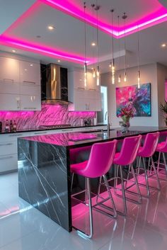 a modern kitchen with pink chairs and marble counter tops in front of the bar area