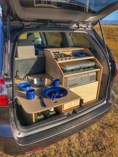 the back end of a car with an open trunk and various items in it on display