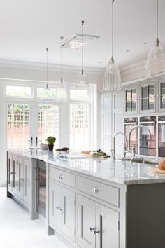 a large kitchen with white cabinets and marble counter tops