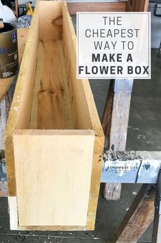 a wooden box with a sign that says the cheapest way to make a flower box