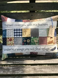 a pillow on a wooden bench that has a message written on it and some fabric