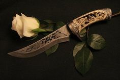 a knife with a white rose on it