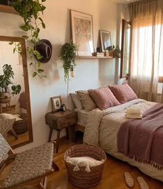 a bed sitting next to a window in a bedroom under a blanket on top of a wooden floor