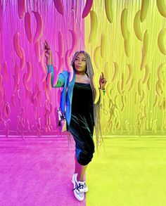 a woman standing in front of a colorful wall