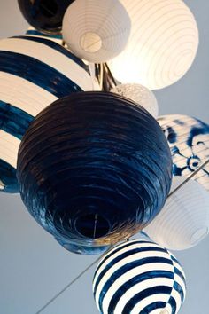 several blue and white paper lanterns hanging from the ceiling