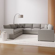 a living room with a large sectional couch and white rug on the wooden flooring