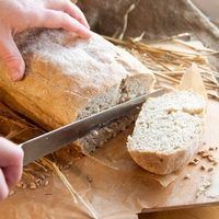 a person cutting bread with a knife