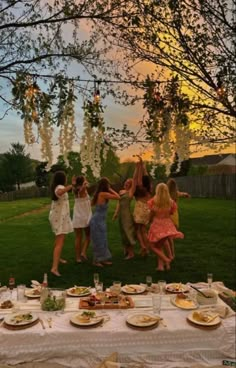 a group of people standing around a table covered in plates and bowls with food on it