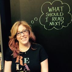 a woman with glasses standing in front of a chalkboard that says what should i read next?