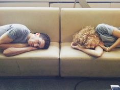 two people laying on couches with their heads together, one is sleeping and the other is lying down