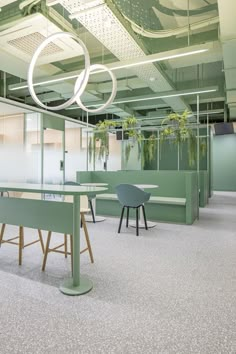 an empty conference room with green chairs and plants on the tables in front of them