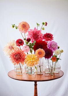 there are many different flowers in vases on the table