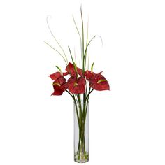 a glass vase filled with red flowers on top of a table