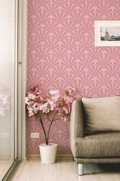 a living room with pink wallpaper and flowers in a vase next to the couch