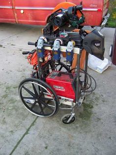 a red bus parked next to a pile of different types of equipment on the street