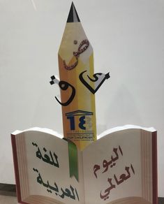 an open book with arabic writing on it and a pencil sticking out of the pages