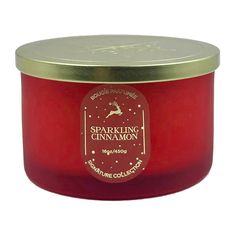 a red candle with a gold lid and label on the top that says sparkling cinnamon