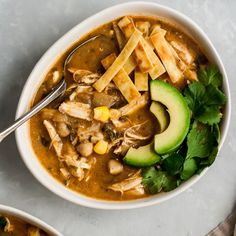 two bowls of chicken tortilla soup with avocado