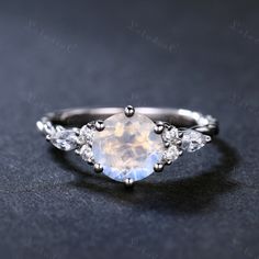 This is 7mm Round cut natural moonstone engagement ring. The accent stones are VVS man made cz diamond. The stones can be replace with other gemstones.For example,if you don't like the CZ accent,you can ask me replace it with tourmaline,aquamarine,diamond,emerald,sapphire... For custom making jewelry,it can be made in 2 different metal(Please contact me if you need this one made in solid gold). 1,Solid gold,including 14/18k white/rose/yellow gold. 2,925 sterling silver with white/yellow/rose gol Moon Stone Ring Engagement, White Gold Opal Ring For Promise, Moonstone Birthstone Ring With Diamond In Round Cut, White Gold Moonstone Ring For Promise, Moonstone Wedding Rings, White Gold Opal Ring With Moonstone, Moonstone Birthstone Ring With Diamond, Moon Shaped Moonstone Promise Ring, Moon-shaped Moonstone Promise Ring